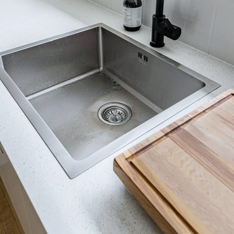 A cleaned stainless steel kitchen sink and worktop.